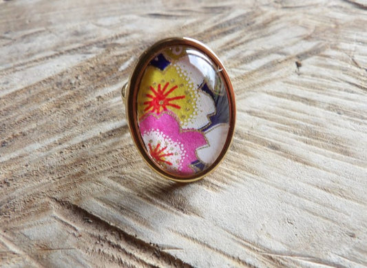 Bague cabochon ovale de 18x25mm - papier japonais fleurs jaunes et roses, fond bleu - acier inoxydable doré