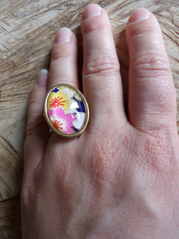 Bague cabochon ovale de 18x25mm - papier japonais fleurs jaunes et roses, fond bleu - acier inoxydable doré